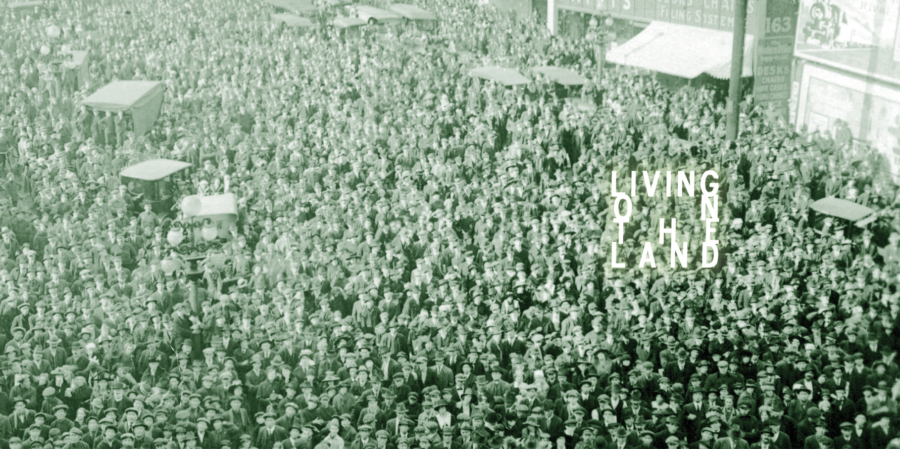 A crowd of people looking up. The words "Living on the Land"